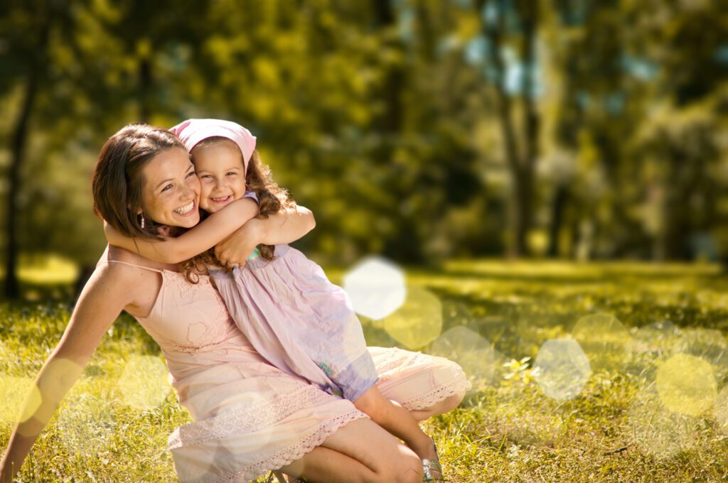 Image of mother and child hugging and smiling, looking very happy.